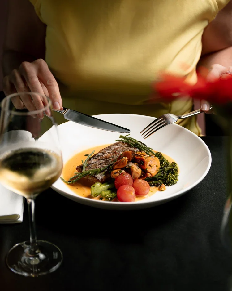 Plato de carne con verduras y vino blanco