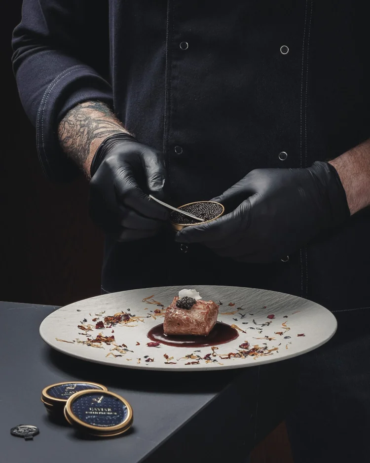 Chef decorando un plato con caviar