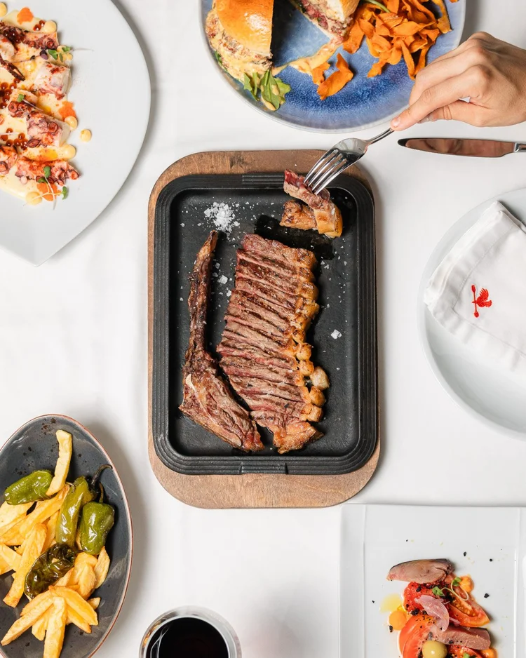 Mesa con carne asada y acompañamientos