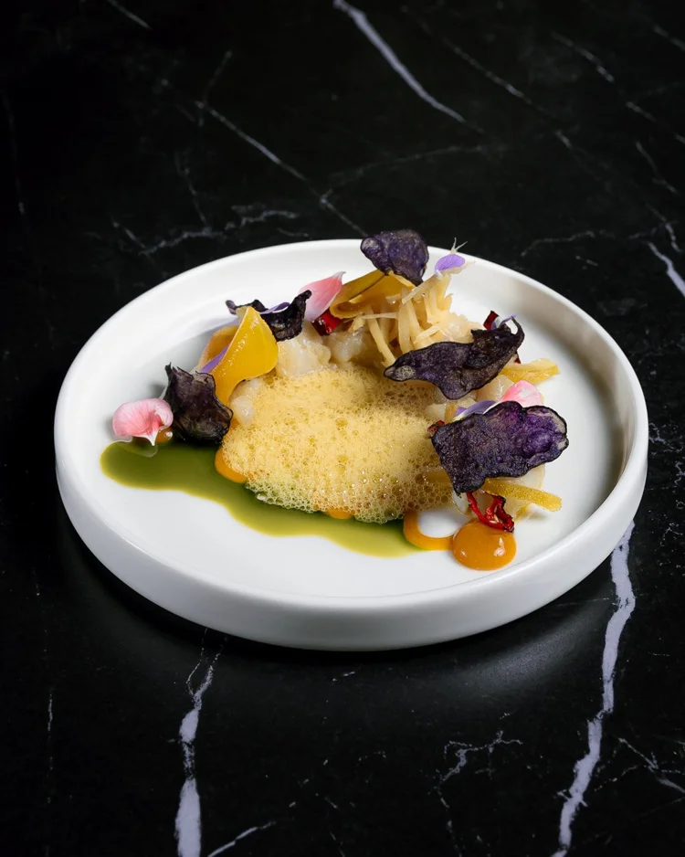 Plato gourmet con espuma y flores