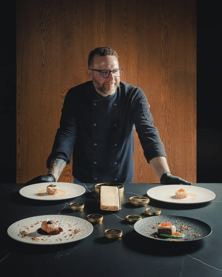 Chef sonriente con platos gourmet