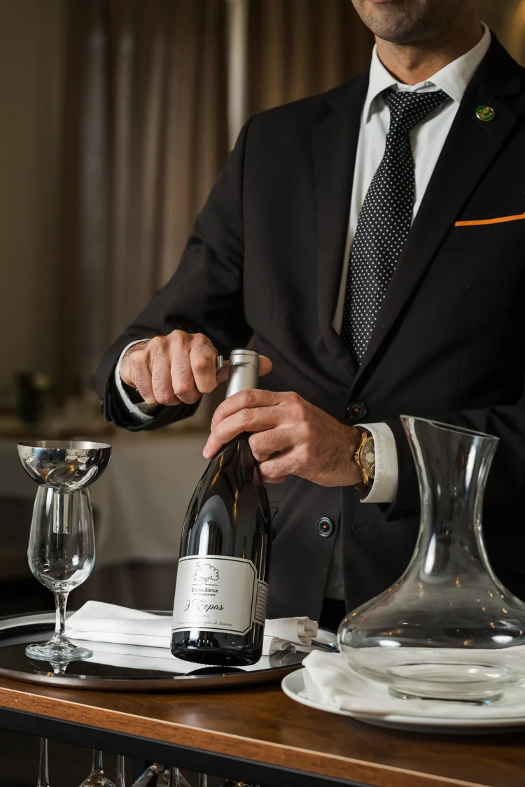 Sommelier abriendo una botella de vino